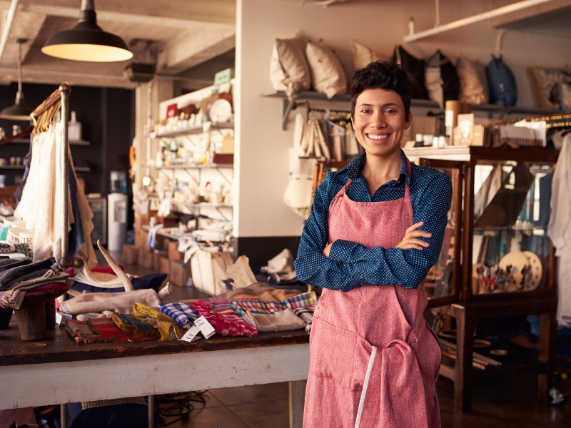 Woman smiling with clothing store in background